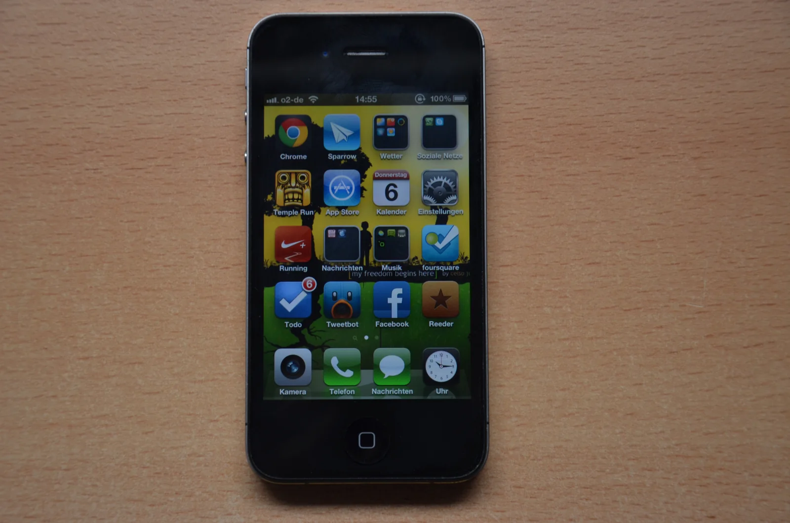 A black iPhone 4S showing its home screen