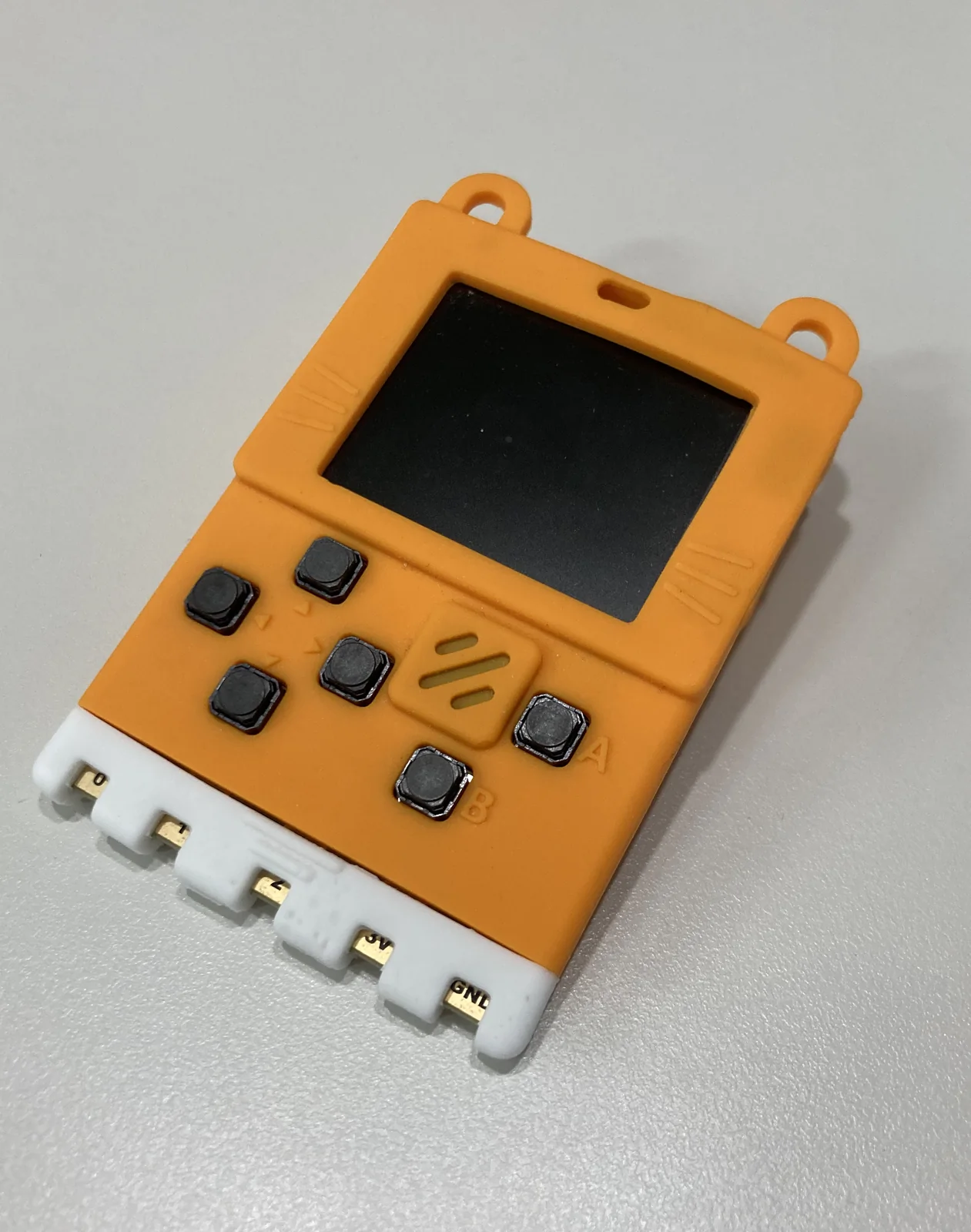 A KittenBot Meowbit handheld on a grey surface
